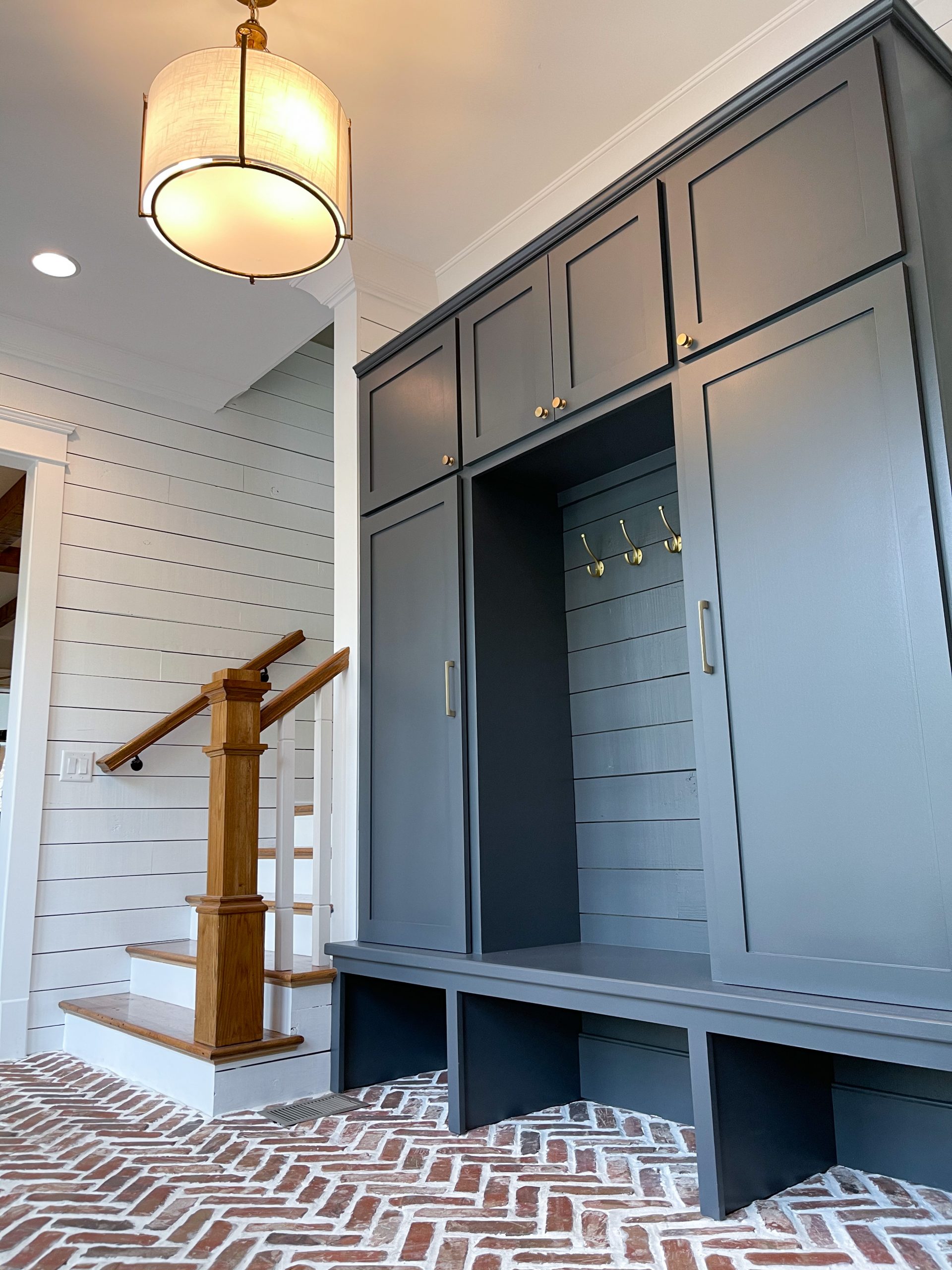 herringbone brick floors navy built-in cabinets white shiplap