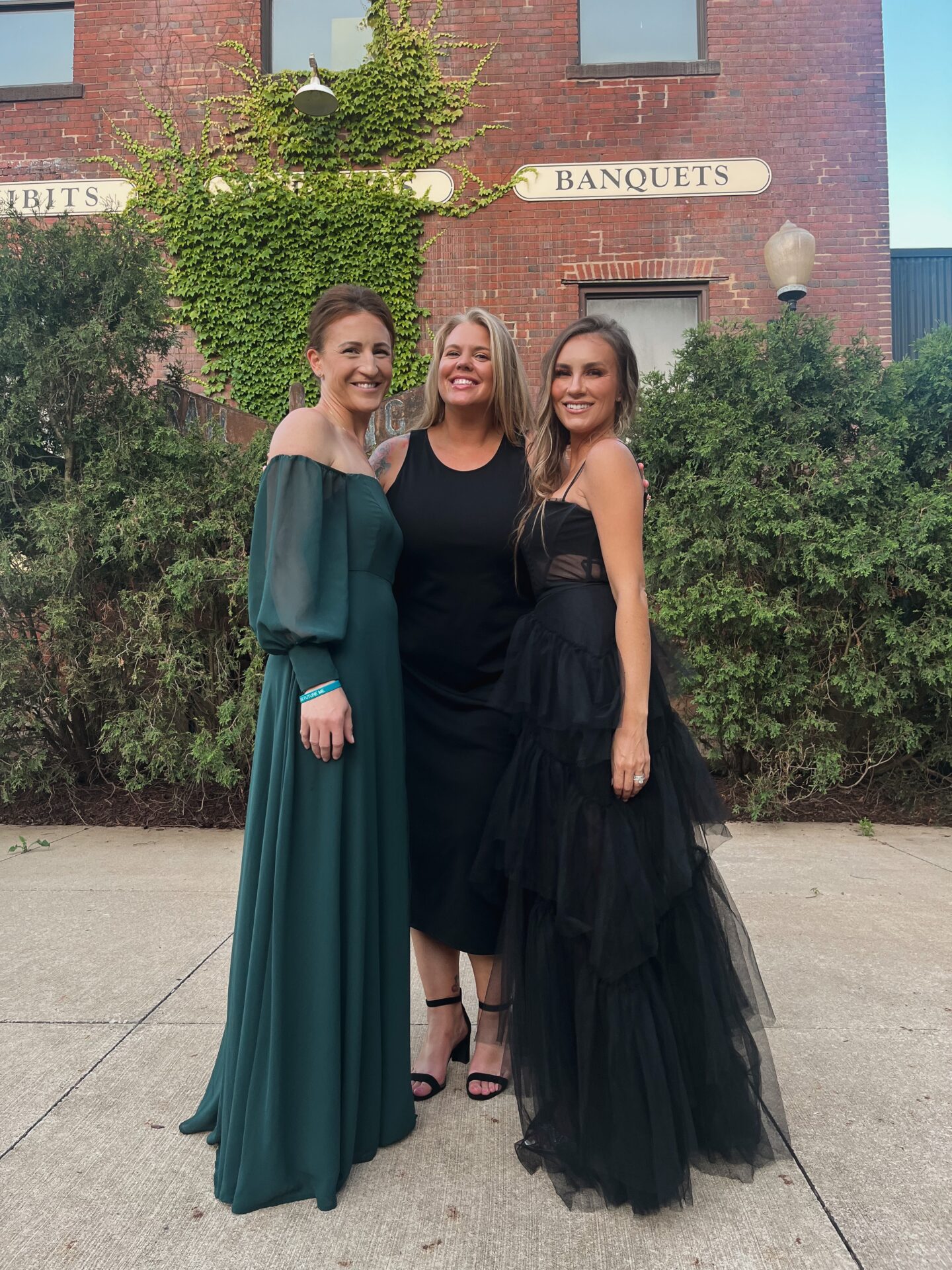 fashion blogger Angela Lanter attending family Greek wedding with friends wearing formal black dress by BCBG Max Azria.