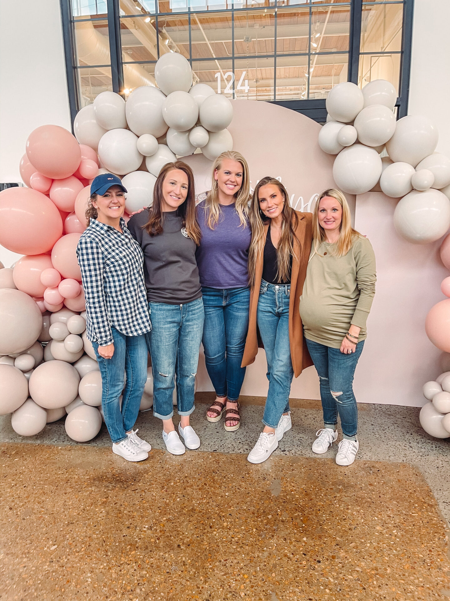 lifestyle blogger Angela Lanter at Nashville shopping mall in front of balloon arch with lifelong friends.