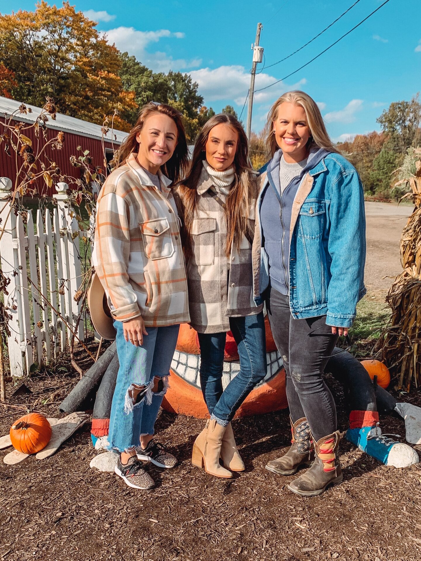 fashion blogger Angela Lanter at Ohio pumpkin farm. Fall fashion outfit wearing plaid shacket, skinny jeans and camel booties with friends.