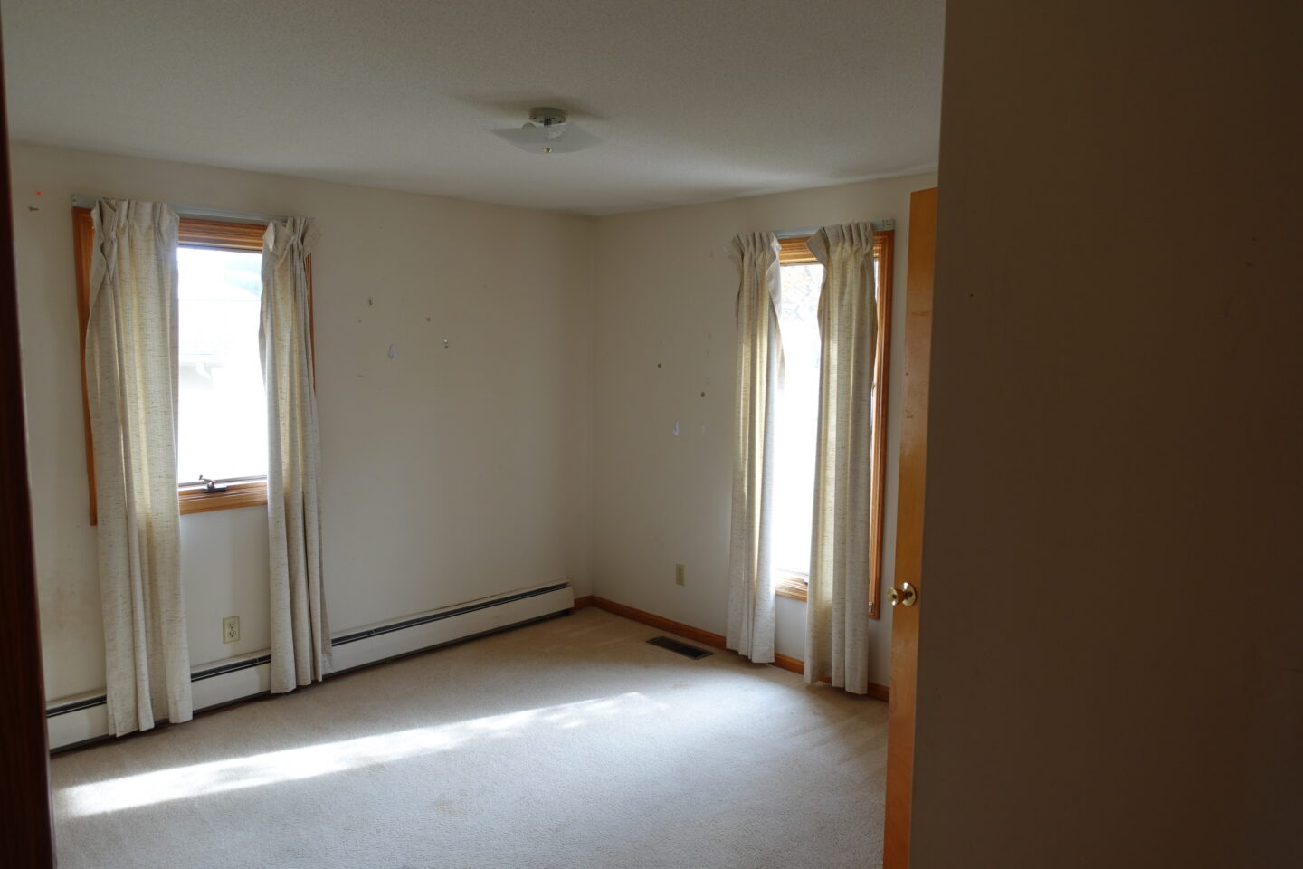 empty bedroom with dated curtains before Ohio house bedroom makeover